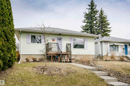 Ranch-style residence featuring light-colored horizontal siding and a dark shingle roof - 9760 64 Avenue, Edmonton, AB - Outdoor