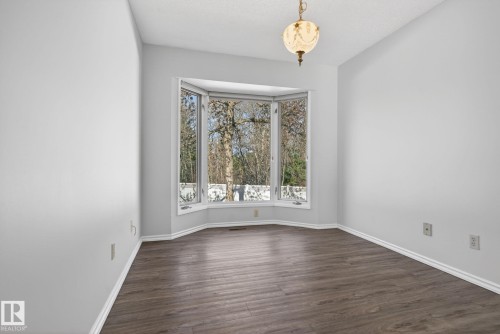Bright interior space featuring a large bay window, wood-finish flooring, and white baseboards - 46 903 109 Street, Edmonton, AB - Indoor Photo Showing Other Room