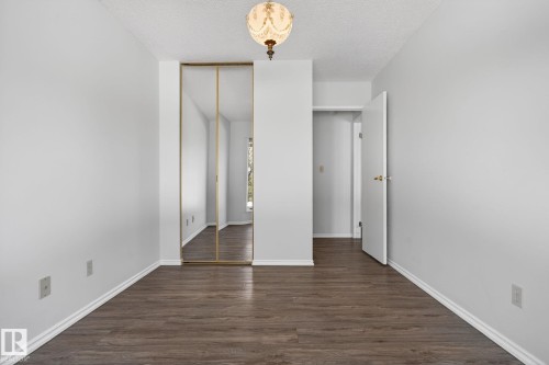 Room featuring wood-finish flooring, light gray walls, white baseboards, and a ceiling-mounted light fixture - 46 903 109 Street, Edmonton, AB - Indoor Photo Showing Other Room