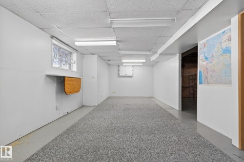 Spacious interior room featuring a drop ceiling, fluorescent lighting, and a light-toned carpet runner - 46 903 109 Street, Edmonton, AB - Indoor Photo Showing Other Room