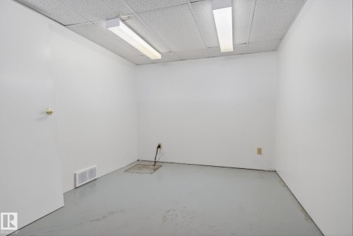 White-painted room with drop ceiling, grey floor, and fluorescent lighting - 46 903 109 Street, Edmonton, AB - Indoor Photo Showing Other Room