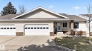 Siding exterior featuring a double-car garage with panel windows, a concrete driveway, and a front entry with a storm door - 46 903 109 Street, Edmonton, AB  - Outdoor With Facade 