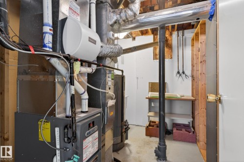 Utility area featuring a furnace system with integrated humidifier, exposed ductwork, and unfinished wall studs - 46 903 109 Street, Edmonton, AB - Indoor Photo Showing Basement