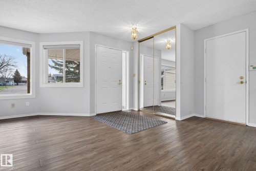 Entryway featuring wood-finish flooring, white trim, and a full-height mirrored closet - 46 903 109 Street, Edmonton, AB - Indoor Photo Showing Other Room