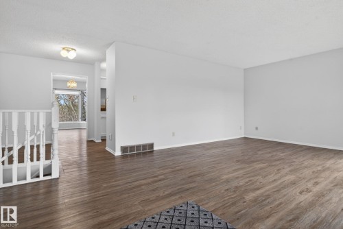 Spacious interior featuring wood-finish flooring and light gray walls - 46 903 109 Street, Edmonton, AB - Indoor Photo Showing Other Room