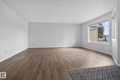 Open-concept living space featuring wood-finish flooring, white baseboards, and neutral wall paint - 46 903 109 Street, Edmonton, AB - Indoor Photo Showing Other Room