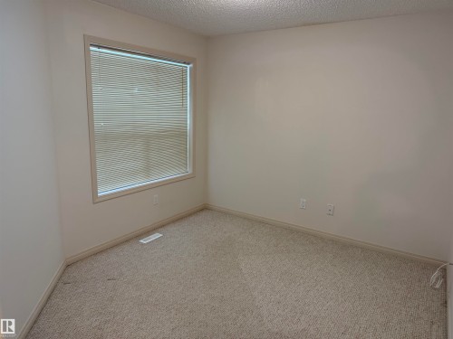 Neutral-toned walls complement the carpeted flooring - 14 330 Galbraith Close, Edmonton, AB - Indoor Photo Showing Other Room