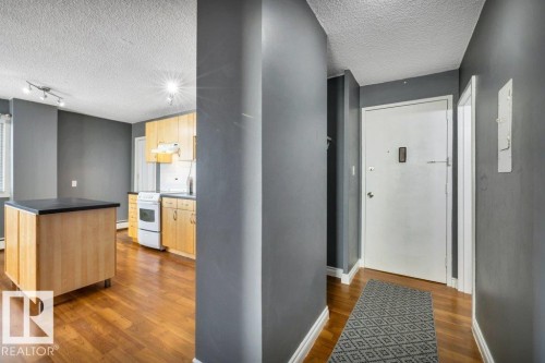 Entryway featuring wood-finish flooring and a white entry door - 403 10021 116 Street, Edmonton, AB - Indoor