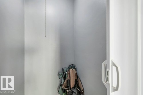 White wall paneling with a sliding door and minimalist handle - 403 10021 116 Street, Edmonton, AB - Indoor Photo Showing Other Room