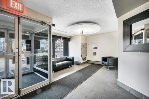 Building entrance featuring glass doors, tile flooring, and a recessed ceiling light fixture - 403 10021 116 Street, Edmonton, AB - Indoor Photo Showing Other Room