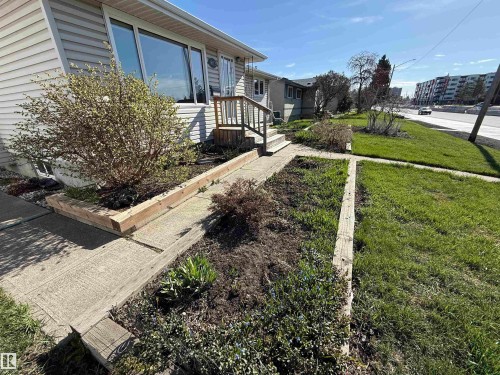 Concrete pathway leading to a front entry, framed by established garden beds and a manicured lawn - 16112 87 Avenue, Edmonton, AB - Outdoor
