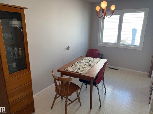 Bright dining area featuring a multi-pane window, flush-mount lighting fixture, and light-toned vinyl flooring - 16112 87 Avenue, Edmonton, AB - Indoor