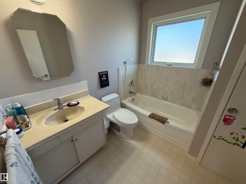 Bathroom featuring a single vanity with a white cabinet base, an integrated sink, and a chrome faucet - 16112 87 Avenue, Edmonton, AB - Indoor Photo Showing Bathroom