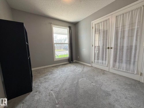 Room featuring gray carpet flooring, neutral gray wall paint, and white baseboards - 5 2204 118 Street, Edmonton, AB - Indoor Photo Showing Other Room