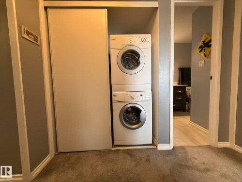 Laundry closet featuring a stacked white washer and dryer unit - 5 2204 118 Street, Edmonton, AB - Indoor Photo Showing Laundry Room