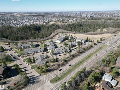 Aerial perspective showcasing a residential development with multiple buildings and surrounding natural areas - 5 2204 118 Street, Edmonton, AB - Outdoor With View