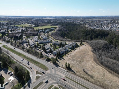 Aerial perspective showcasing a residential development bordering a wooded area and open land - 5 2204 118 Street, Edmonton, AB - Outdoor With View