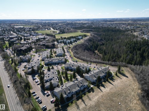 Aerial perspective showcasing a residential community with multiple buildings featuring gray roofs and light-colored exteriors - 5 2204 118 Street, Edmonton, AB - Outdoor With View