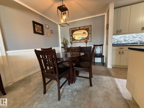 Dining area with neutral carpeting and wainscoting - 5 2204 118 Street, Edmonton, AB - Indoor Photo Showing Dining Room