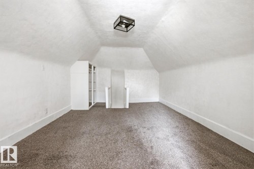A spacious room with sloped ceilings and natural light. - 10927 93 Street Nw, Edmonton, AB - Indoor Photo Showing Other Room