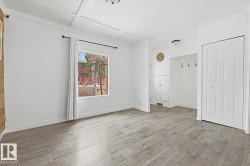 This living area features light-colored flooring, white walls, and lots of natural light. - 