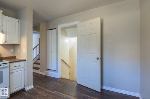 Kitchenette area featuring wood-finish flooring, white cabinetry, and a stone-look countertop - 8039 27 Avenue, Edmonton, AB - Indoor Photo Showing Kitchen