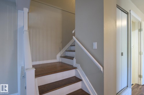 Staircase featuring wood-finish treads, painted risers, and a white handrail - 8039 27 Avenue, Edmonton, AB - Indoor Photo Showing Other Room