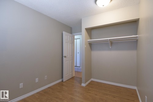 Interior room featuring wood-finish flooring, light neutral-toned walls, and white baseboards - 8039 27 Avenue, Edmonton, AB - Indoor