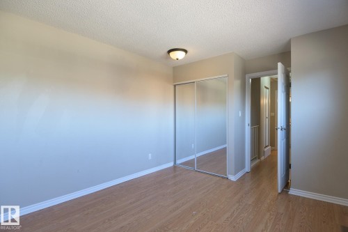 Room featuring wood-finish flooring, neutral wall tones, and white baseboards - 8039 27 Avenue, Edmonton, AB - Indoor Photo Showing Other Room
