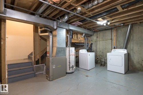 Utility area featuring a furnace, water heater, washer, and dryer - 8039 27 Avenue, Edmonton, AB - Indoor Photo Showing Laundry Room