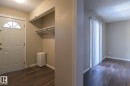 Entryway featuring a white paneled door with an arched transom window, wood-finish flooring, and an integrated storage nook with shelving - 8039 27 Avenue, Edmonton, AB  - Indoor Photo Showing Other Room 