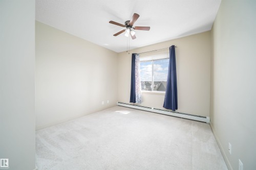 Light-colored carpeting and neutral wall tones create an open atmosphere - 421 4008 Savaryn Drive, Edmonton, AB - Indoor Photo Showing Other Room
