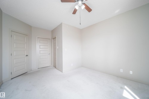 Bedroom featuring light-toned walls and carpet flooring - 421 4008 Savaryn Drive, Edmonton, AB - Indoor Photo Showing Other Room