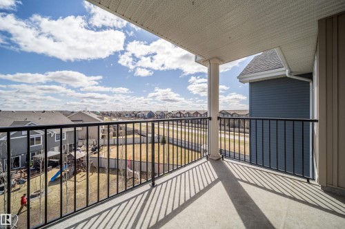 Exterior balcony featuring a concrete floor, black metal railings, a white support column, and a textured white soffit ceiling - 421 4008 Savaryn Drive, Edmonton, AB - Outdoor With Exterior