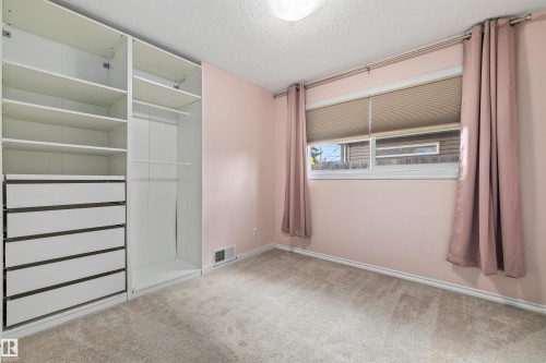 Bedroom featuring built-in white cabinetry with drawers, shelving, and hanging rods - 7927 71 Avenue, Edmonton, AB - Indoor Photo Showing Other Room
