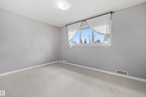 Room featuring light gray walls, white baseboards, and neutral-toned carpet flooring - 7927 71 Avenue, Edmonton, AB - Indoor Photo Showing Other Room