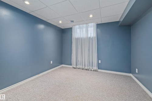 Room featuring textured carpet flooring, blue painted walls, recessed lighting, and a drop ceiling - 7927 71 Avenue, Edmonton, AB - Indoor Photo Showing Other Room