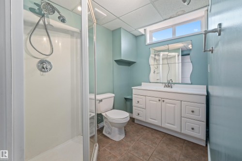 Bathroom featuring a white vanity with integrated sink, chrome faucet, and a large mirror - 7927 71 Avenue, Edmonton, AB - Indoor Photo Showing Bathroom