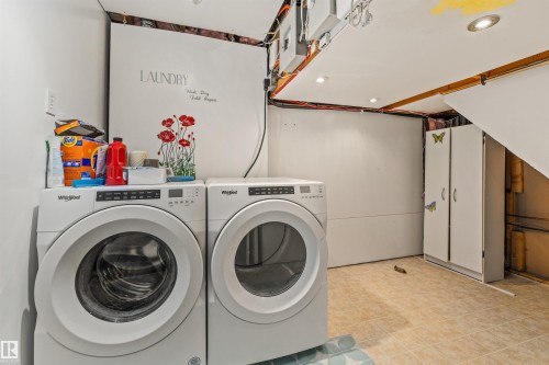 Dedicated laundry area featuring a front-load washer and dryer, tile flooring, recessed lighting, and white storage cabinetry - 7927 71 Avenue, Edmonton, AB - Indoor Photo Showing Laundry Room