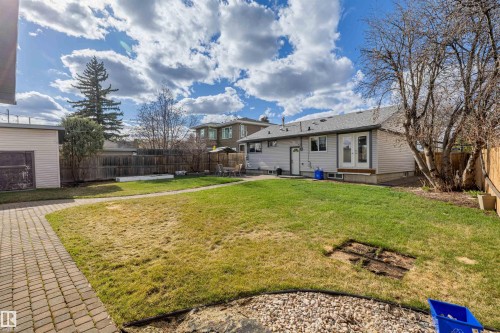 Expansive backyard featuring a paver stone pathway, mature trees, and a detached auxiliary structure - 7927 71 Avenue, Edmonton, AB - Outdoor