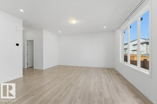Bright open living space with light-toned wood-finish flooring - 2011 207 Street, Edmonton, AB - Indoor Photo Showing Other Room