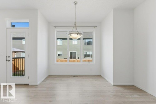 Dining space featuring light wood-finish flooring and a contemporary overhead light fixture - 2011 207 Street, Edmonton, AB - Indoor Photo Showing Other Room