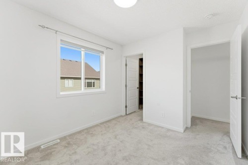 Bright room featuring light grey carpeting, white walls, and a multi-pane window - 2011 207 Street, Edmonton, AB - Indoor Photo Showing Other Room