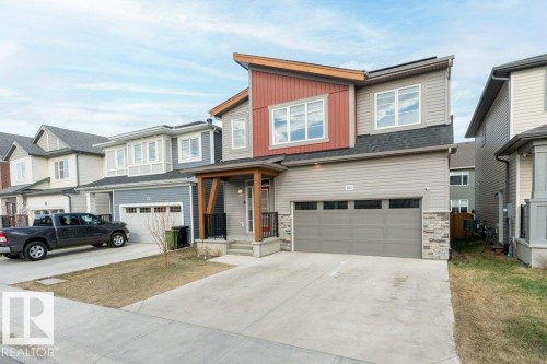 Contemporary two-story residence featuring a multi-textured exterior with horizontal siding, vertical panels, and stone accents - 2011 207 Street, Edmonton, AB - Outdoor With Facade