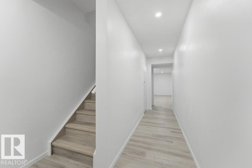 Hallway featuring wood-finish flooring, recessed lighting, and white baseboards - 2011 207 Street, Edmonton, AB - Indoor Photo Showing Other Room