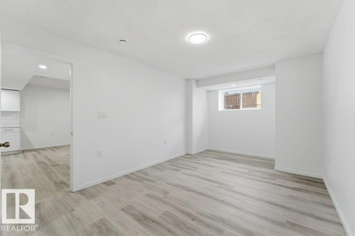 Open concept room featuring wood-finish flooring, recessed lighting, and a window - 2011 207 Street, Edmonton, AB - Indoor Photo Showing Other Room