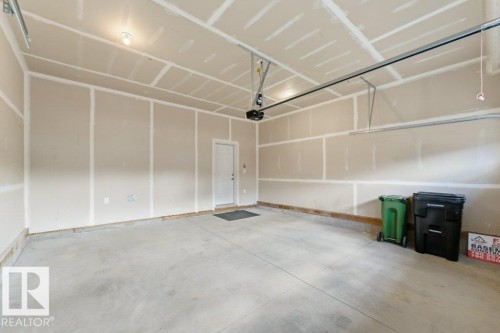 Spacious garage featuring a concrete floor, overhead lighting, and an interior access door - 2011 207 Street, Edmonton, AB - Indoor