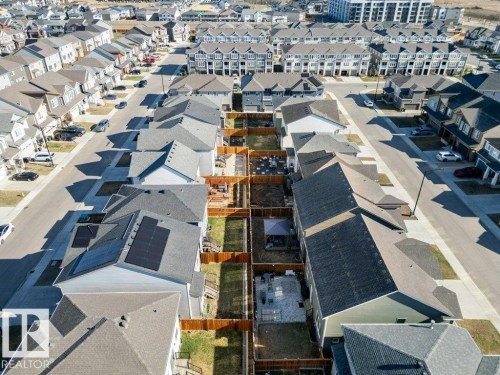 Residential neighborhood featuring a mix of detached homes and townhomes, paved streets, private fenced backyards, and solar panel installations on select roofs - 2011 207 Street, Edmonton, AB - Outdoor With View
