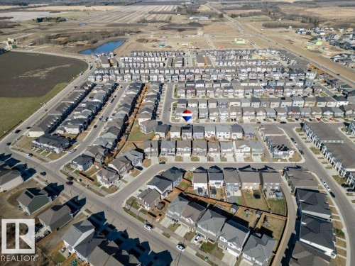 Aerial perspective of a developed residential community featuring numerous single-family homes and townhomes with dark-toned roofs - 2011 207 Street, Edmonton, AB - 