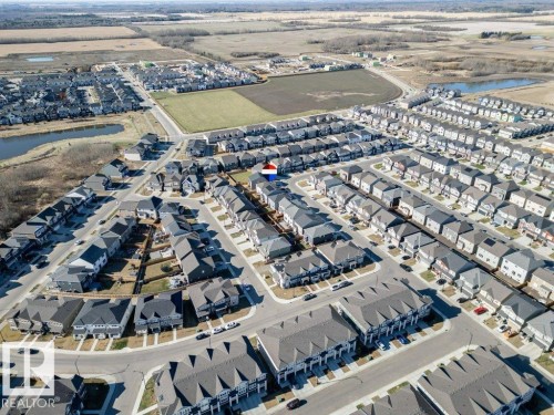 Expansive residential development featuring a structured street grid, uniform housing styles, varied rooflines, and adjacent undeveloped land - 2011 207 Street, Edmonton, AB - Outdoor With View